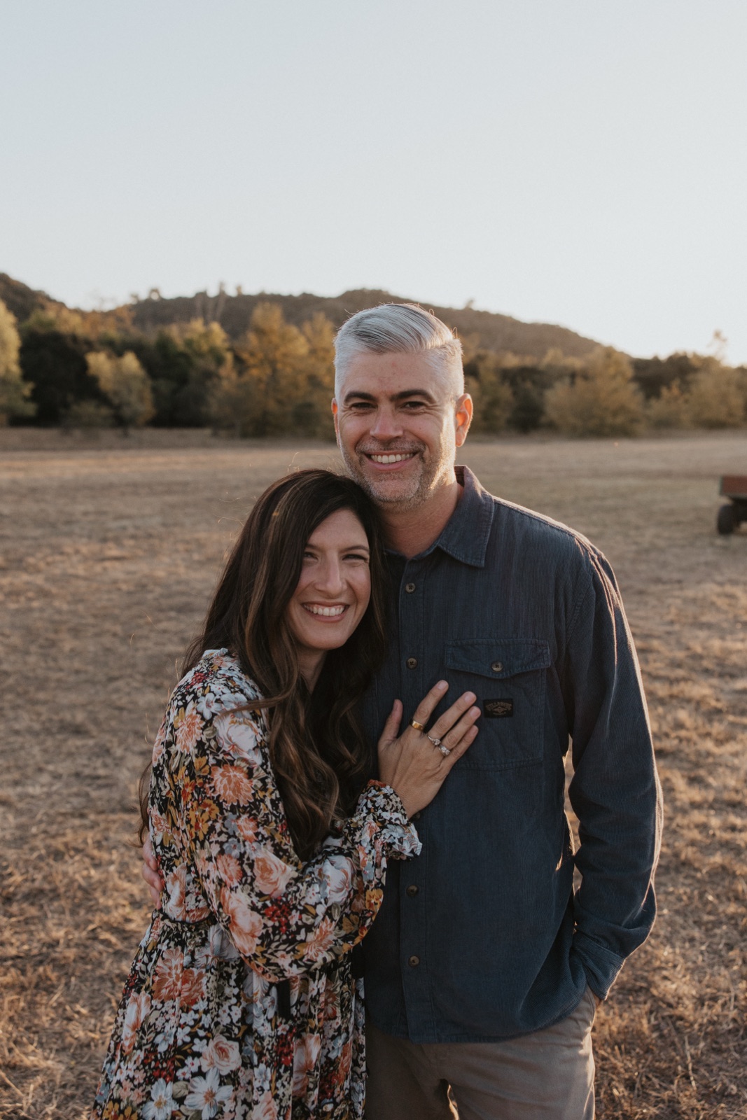 Jamin and Kristin standing together in an open field at golden hour