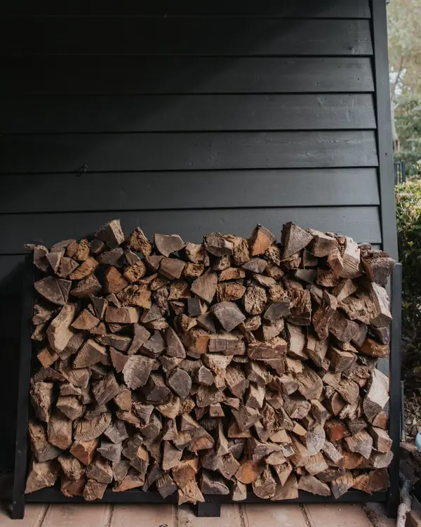 Split firewood stacked against a dark wall